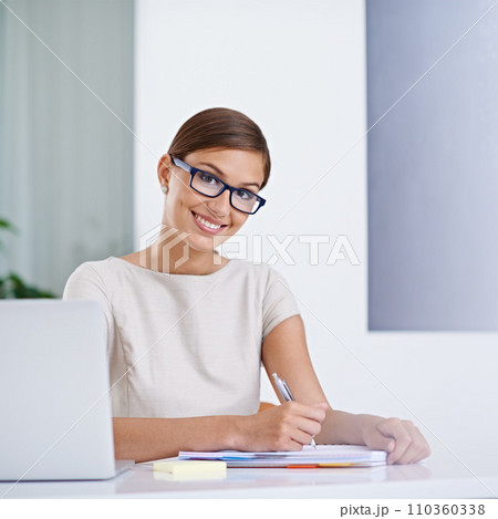 I just need to take a few details down. Portrait of an attractive young business woman working. 110360338