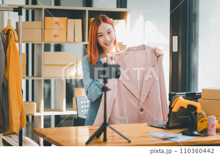 SME owner using the smartphone and tablet for recording video. vlog and live stream at her shop,SME business concept, online shopping. 110360442