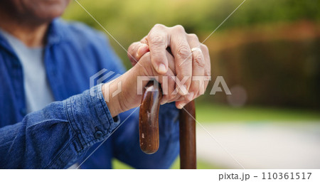 Senior, person or hands with closeup of walking stick for mobility support, balance or alzheimer in park. Elderly, man or cane outdoor in nature for healthcare, arthritis or rehabilitation for health 110361517