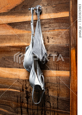 Wet swimsuit hanging on hook after swimming. Wet swimsuit hanging on hook after swimming. 110363463