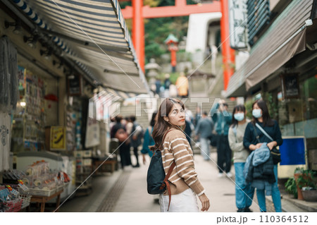 Woman tourist Visiting in Enoshima Island, Fujisawa, Kanagawa, Japan. happy Traveler sightseeing Enoshima Shrine. Landmark and popular for tourists attraction near Tokyo. Travel and Vacation concept Woman tourist Visiting in Enoshima Island, Fujisawa, Kanagawa, Japan. happy Traveler sightseeing Enoshima Shrine. Landmark and popular for tourists attraction near Tokyo. Travel and Vacation concept 110364512