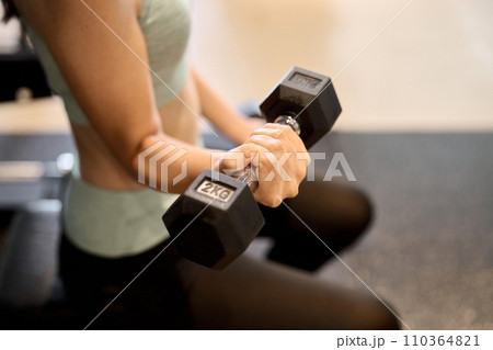 ダンベルアームカールで腕を鍛える女性 ダンベルアームカールで腕を鍛える女性 110364821