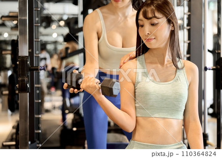 ダンベルアームカールで腕を鍛える女性 ダンベルアームカールで腕を鍛える女性 110364824
