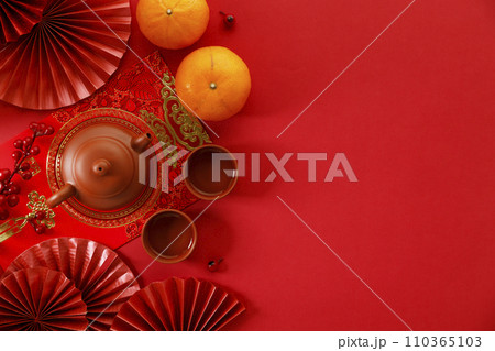 Chinese new year festival decorations with tangerines, classic clay teapot and red Chinese folded fans. 110365103