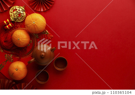Chinese new year festival decorations with tangerines, classic clay teapot and red Chinese folded fans. 110365104