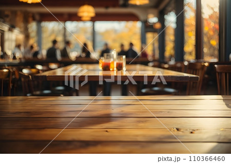 Empty wooden table top with restaurant full of guests in background with bokeh autumn sunlight. Empty wooden table top with restaurant full of guests in background with bokeh autumn sunlight. 110366460