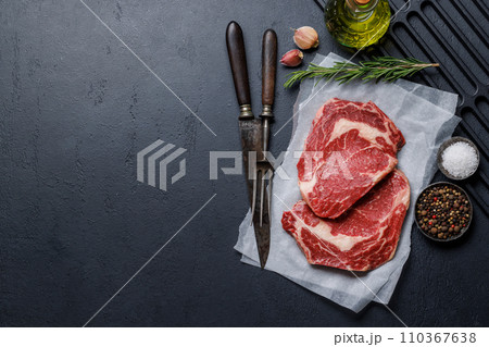 Raw ribeye steaks with savory spices 110367638