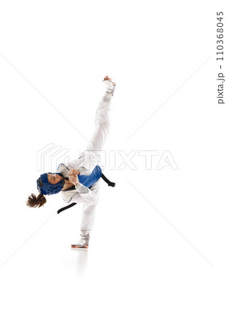 Athletic young girl in dobok and blue helmet practicing, training taekwondo isolated over white background Athletic young girl in dobok and blue helmet practicing, training taekwondo isolated over white background 110368045