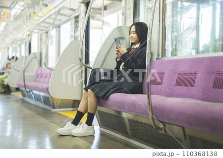 電車の中でスマートフォンを見る女子高校生 電車の中でスマートフォンを見る女子高校生 110368138