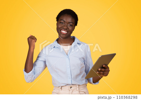Glad young african american lady student in casual show tablet celebrate win, success Glad young african american lady student in casual show tablet celebrate win, success 110368298