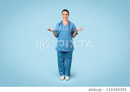 Happy woman nurse with open hands in blue scrubs Happy woman nurse with open hands in blue scrubs 110368305