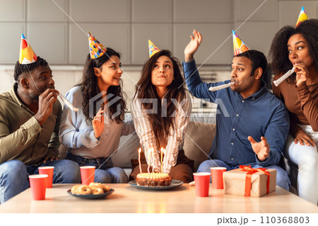 Students enjoying weekend birthday party, woman making wish indoors Students enjoying weekend birthday party, woman making wish indoors 110368803