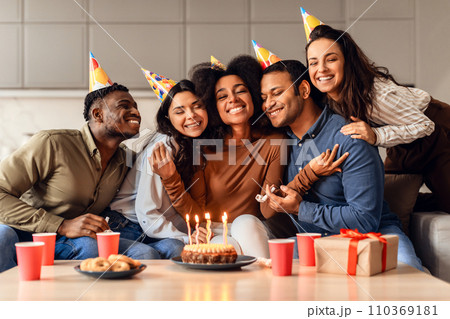 Joyful multicultural friends hugging bday lady celebrating and partying indoor Joyful multicultural friends hugging bday lady celebrating and partying indoor 110369181