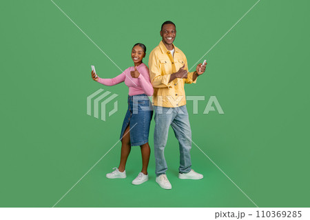 Happy black man and woman with phones in their hands 110369285