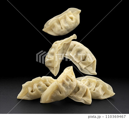 Falling Chinese Gyoza dumplings isolated on black background with copy space 110369467