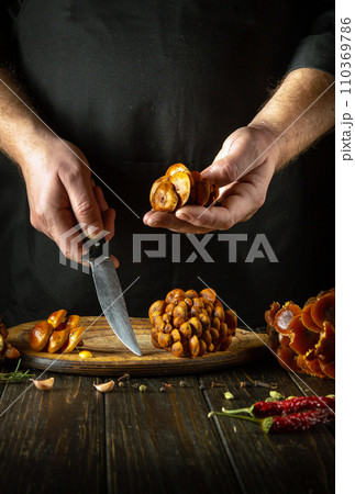 Flammulina velutipes and a knife in the hands of a chef before sorting and slicing on a kitchen cutting board. Delicious dietary lunch of fresh forest velvet shank or wild enoki 110369786