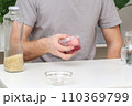 A man lays an egg and shakes a container of rice 110369799