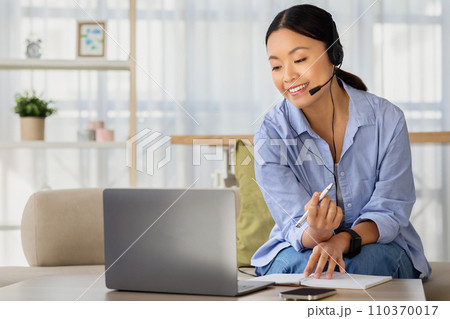 Positive millennial chinese woman working or studying from home 110370017