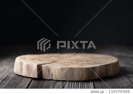 Wooden plate carved from tree trunk on old grunge wooden table 110370308