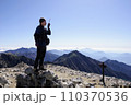 山頂で無線をする男性 110370536