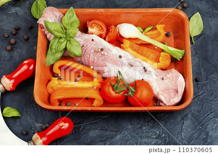 Raw uncooked meat tenderloin in a baking dish. Raw uncooked meat tenderloin in a baking dish. 110370605