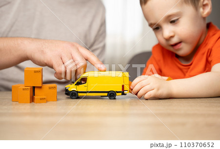 The father tells the boy how order packages are delivered. Home business, shipping orders. Logistics industry. Freight transportation. Last-mile delivery services. House moving. 110370652