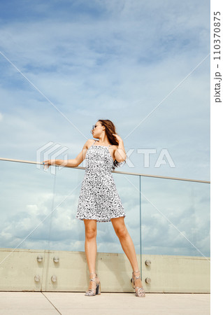 Full length portrait of pretty woman in sundress on balcony 110370875