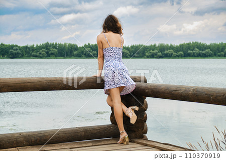 Unrecognizable woman standing on wooden pier Unrecognizable woman standing on wooden pier 110370919