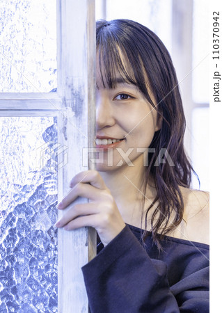窓からのぞく黒ワンピースの若い女性 110370942