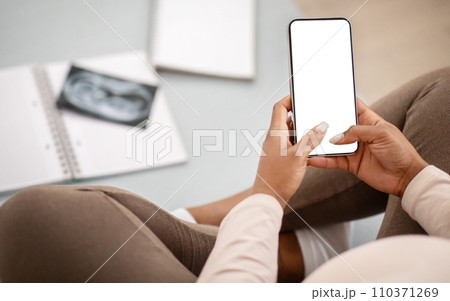 Cropped of pregnant black woman using phone with blank screen Cropped of pregnant black woman using phone with blank screen 110371269
