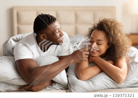 Loving Black Young Man Touching Wife's Nose Flirting In Bed Loving Black Young Man Touching Wife's Nose Flirting In Bed 110371321