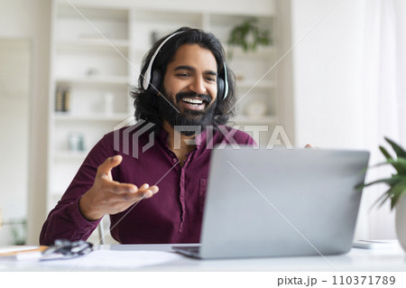 Web Conference. Smiling Indian Man In Headphones Making Video Call Via Laptop 110371789