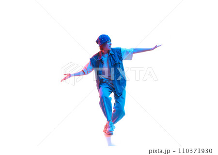 Young girl wearing casual jean clothes and head accessories dancing hip hop isolated over white background in neon light 110371930