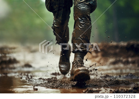 Close up legs of a soldier running on rainy muddy ground 110372328