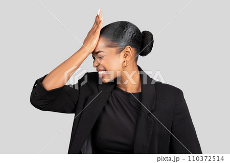 Sad young african american woman in formal suit put hand to forehead 110372514