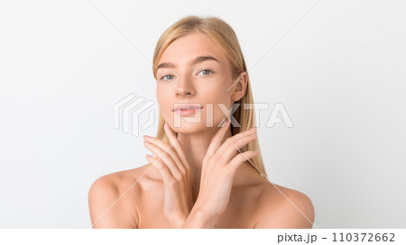 blonde lady posing holding hands near face over white backdrop blonde lady posing holding hands near face over white backdrop 110372662