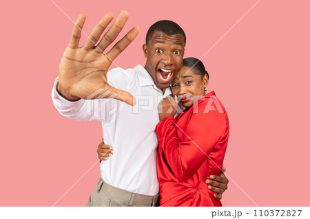 Black man gesturing stop with a fearful look, woman clinging to him Black man gesturing stop with a fearful look, woman clinging to him 110372827