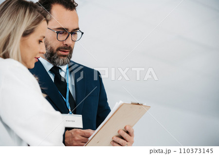 Pharmaceutical sales representative talking with female doctor in medical building. Hospital director consulting with healthcare staff. Pharmaceutical sales representative talking with female doctor in medical building. Hospital director consulting with healthcare staff. 110373145