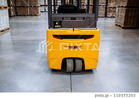 Back view of forklift in warehouse in the middle of stored goods.. Forklift driver preparing products for shipmennt, delivery, checking stock in warehouse. 110373203