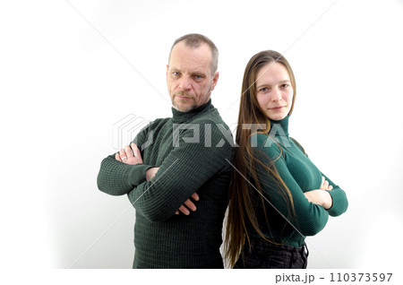 A man and a woman on a white background posing in a studio photo shoot press their backs to each other straighten their hair strike a pose, confident look, green clothes a couple of people A man and a woman on a white background posing in a studio photo shoot press their backs to each other straighten their hair strike a pose, confident look, green clothes a couple of people 110373597
