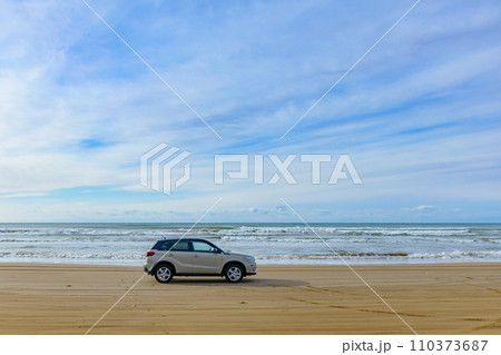 能登半島・千里浜なぎさドライブウェイの砂浜と一台の車 能登半島・千里浜なぎさドライブウェイの砂浜と一台の車 110373687