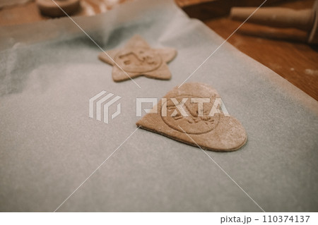 Process of making heart-shaped gingerbread for Christmas and New Year. Traditional festive food making, family culinary.  110374137