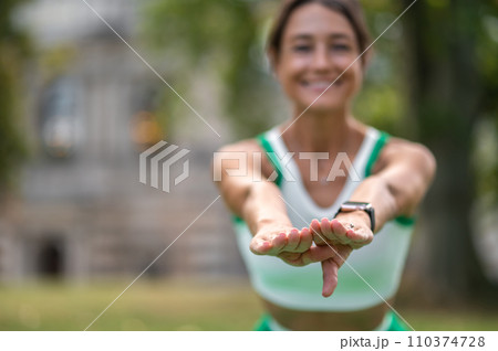 Cute dark-haired woman doing squats and smiling Cute dark-haired woman doing squats and smiling 110374728
