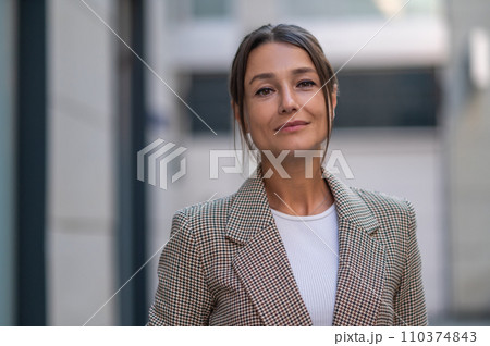 Woman wearing beige suit posing near urban building. Woman wearing beige suit posing near urban building. 110374843