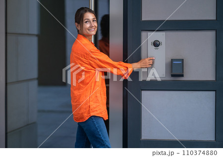 Woman using modern keypad system maintains control over access to her home. 110374880