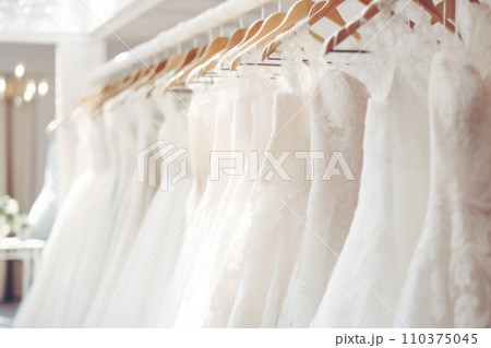 A lot of wedding dresses are hanging on hangers in the salon 110375045