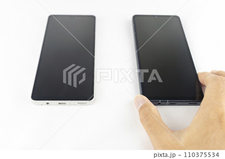 スマートフォンの機種変更をする男性の手元 スマートフォンの機種変更をする男性の手元 110375534