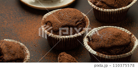Chocolate and cocoa browny muffins with coffee cappuccino in cup angle view on brown rustic stone background, sweet homemade dark chocolate cupcakes Chocolate and cocoa browny muffins with coffee cappuccino in cup angle view on brown rustic stone background, sweet homemade dark chocolate cupcakes 110375578