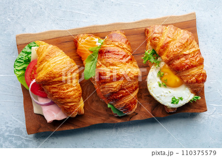 Croissant sandwich variety. Various stuffed croissants, overhead flat lay 110375579
