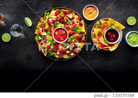 Loaded nachos. Mexican nacho chips with beef, overhead flat lay shot 110375586